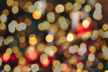 Red christmas decorations on the table at blurred christmas tree with candlesの写真素材