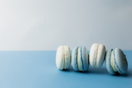 White and blue macaroons on the table, macaroons on blue backgroundの写真素材