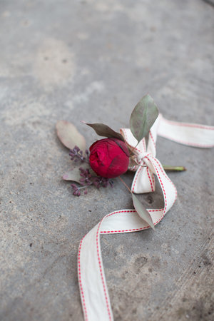 Red rose with ribbon on the concrete ground