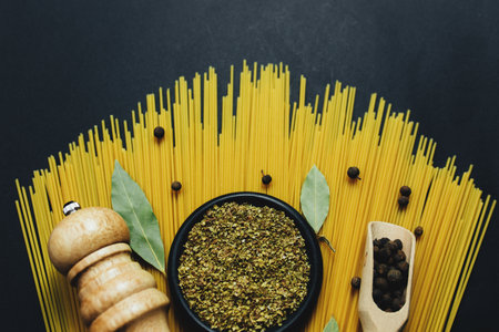Seasonings, herbs and pasta on black backgroundの写真素材