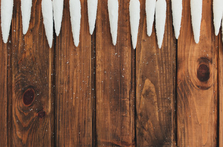 White icicles on old brown wooden backgroundの写真素材