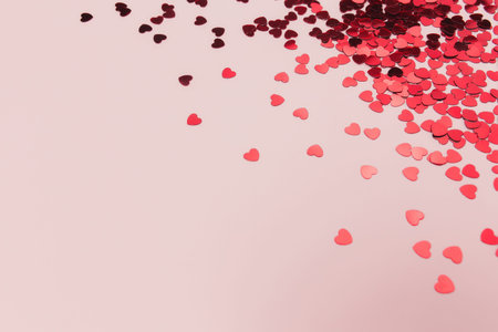 Red heart glitters on the pink background