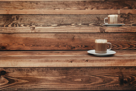 Two cups of coffee in the wooden brown terrace background