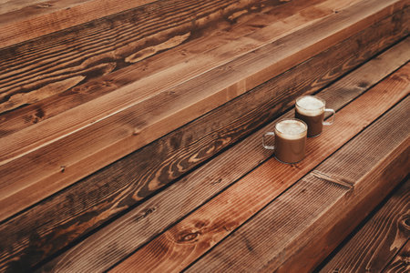 Two cups of coffee in the wooden brown terrace backgroundの写真素材