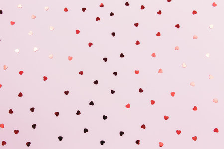 Red heart glitters on the pink background