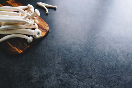 Cooking white mushrooms on the dark gray background