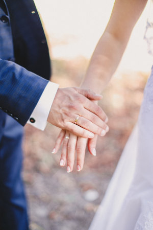 Groom holds bride hand in white dressの写真素材
