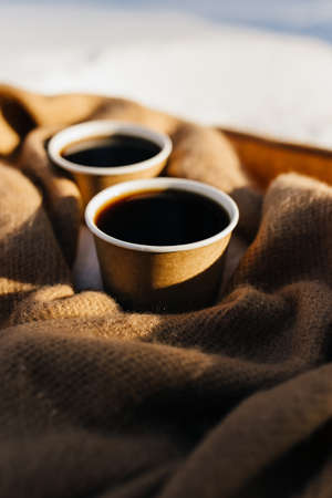 Two cups of coffee on a scarf in the snowy forest. Blurred backgroundの写真素材