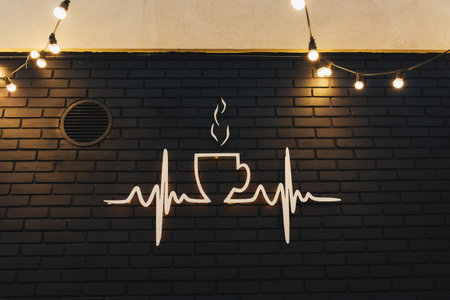 Coffee symbol on black brick wall with garlands