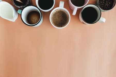 Multiple coffee cups, milk, beans and ground coffee in jar on beige background. High quality photoの写真素材