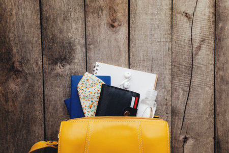 Flat lay travel concept with passports and black wallet, hand bag, face protective mask and...