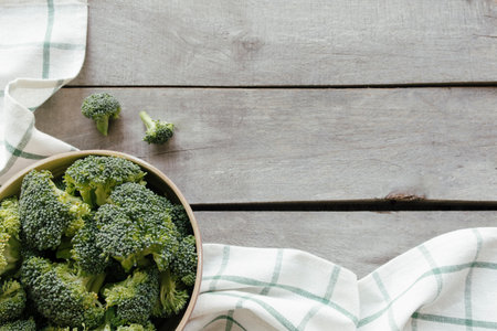 Green fresh broccoli in bowl on wooden background, white towel. Healthy eating concept. High quality photoの写真素材