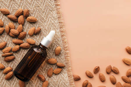 Almond essential oil in glass bottle, raw almond kernels. Cosmetic conceptの写真素材