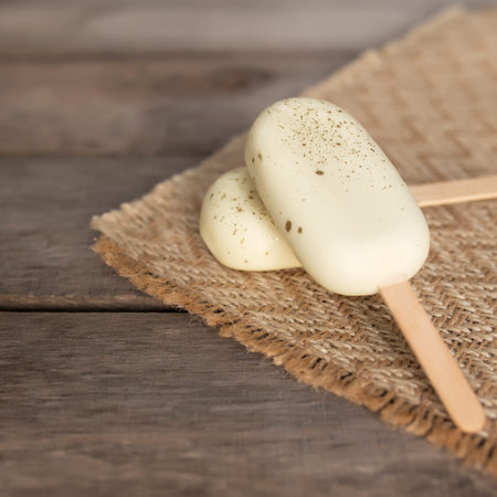 White shiny cookie ice creams on a stick on wooden background. High quality photoの写真素材