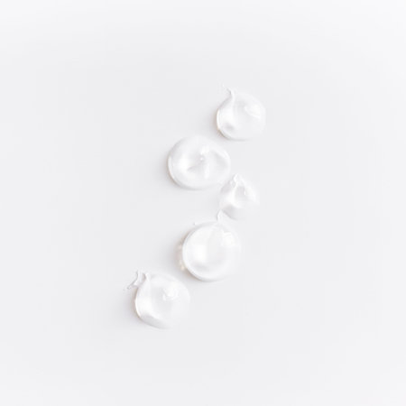 Textures from cosmetics. Smears from transparent body cream on white table