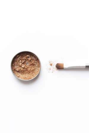 Light brown face shadow in container and eye shadow or make-up brushの写真素材