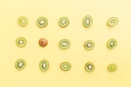 Slices and cuts of kiwi fruit on yellow background. Healthy eating, travel or vacation conceptの写真素材