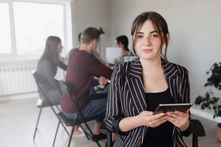 Business planning meeting, young colleagues or partners sitting together at table in conference room with graphics, charts presented by manager, discussing, planning project, budget, analyzing financeの写真素材
