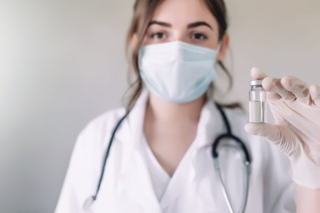Doctor or nurse is holding glass vial bottle of anti virus vaccine