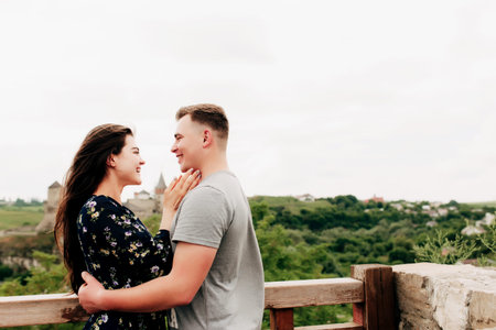 Young Caucasian loving mature couple relaxing during outdoor activities, smiling, hugging and...
