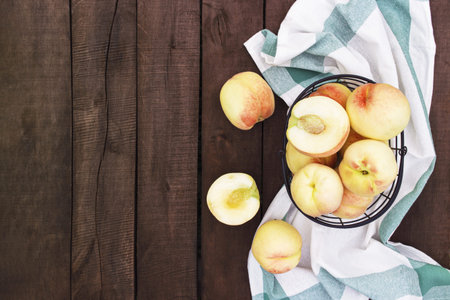 Large and big juicy peaches on brown wooden table background with boardsの写真素材