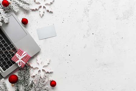 Christmas, New Year shopping gray concrete flat lay. Laptop computer, empty blank credit card, red white paper present gift boxes top view. Fir branch, toy balls, stars. Copy space area on photoの写真素材