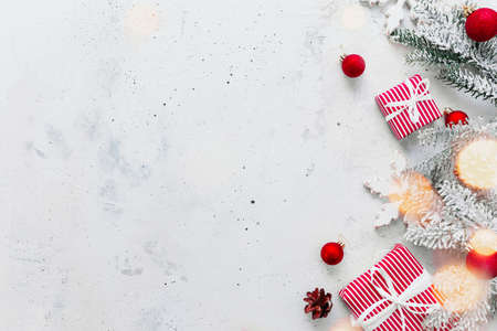 Christmas, New Year gray concrete flat lay. Red white striped present gift boxes top view. Gift ribbon and packaging paper. Christmas tree fir, cones, toy balls, wooden star. Copy space area on photoの写真素材