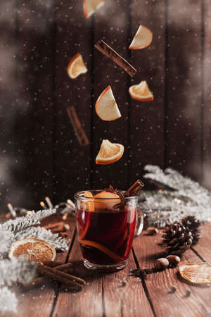 Mulled Wine Christmas cup on table, levitation of cinnamon stick, orange, appleの写真素材
