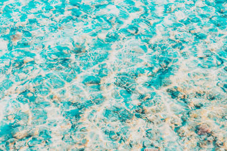 Vibrant blue white ripped water surface with clear transparent waves and nice sun sparkles over the reefs at Red sea or ocean. Conceptual abstract texture background. Travel or vacation summer conceptの写真素材