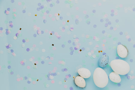 Happy Easter holiday, coming spring concept. Flat lay with white, colorful quail eggs, feather. Blue...