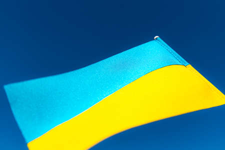Large bicolor yellow blue Ukrainian state flag, national symbol fluttering, waving in wind against blue sky on sunny day. Kyiv city, capital of Ukraine, Independence Constitution Day, National holidayの写真素材