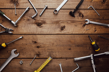 Flat lay with various work tools on wooden background working table. Top view on new hand tool set...
