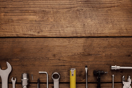 Flat lay with various work tools on wooden background working table. Top view on new hand tool set for repair, construction kit, overhead. Must-have for men. Equipment for building. Industry conceptの写真素材
