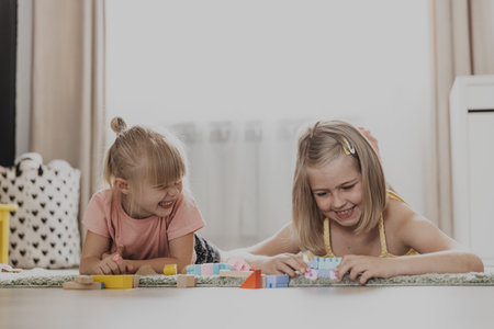 Children playing with colorful toys. Kids sitting on carpet at home bedroom or kindergarten. Development of fine motor skills, imagination, logical thinking concept. Educational eco-friendly gamesの写真素材
