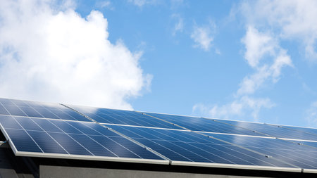 Aerial view of solar panel stand-alone photovoltaic plant system on cloudy blue sky background....