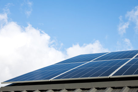 Aerial view of solar panel cells against cloudy blue sky. Alternative energy concept, sustainable resources. House with solar panels stand-alone photovoltaic plant system. Professional installationの写真素材