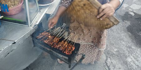Sate Madura (Satay Madura) is a chicken satay served with a lontong sprinkled with peanut sauce and sliced onions. This is a typical Indonesian food.の写真素材