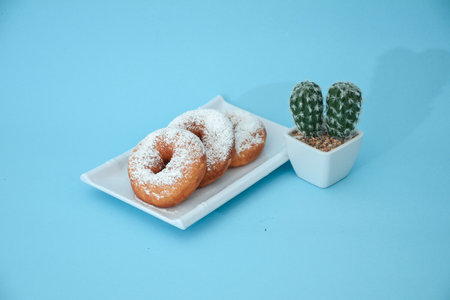 Donut cake with brown grain, there are cactus tree accessories set in light blueの写真素材