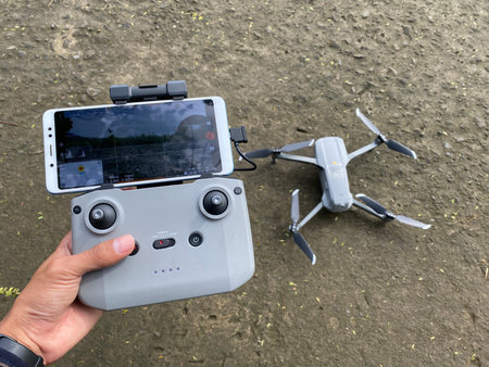 holding a drone remote and a drone to be flown.