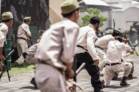 theatrical war general attack 1 march, using war uniforms and weapons in the Dutch colonial era. They shoot each other. : Yogyakarta, Indonesia - 01 March 2022のeditorial素材