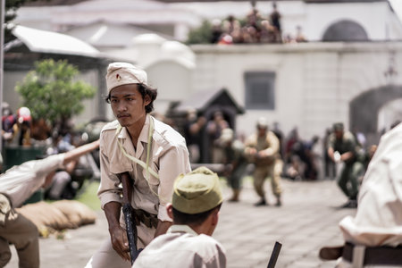 theatrical war general attack 1 march, using war uniforms and weapons in the Dutch colonial era. They shoot each other. : Yogyakarta, Indonesia - 01 March 2022のeditorial素材