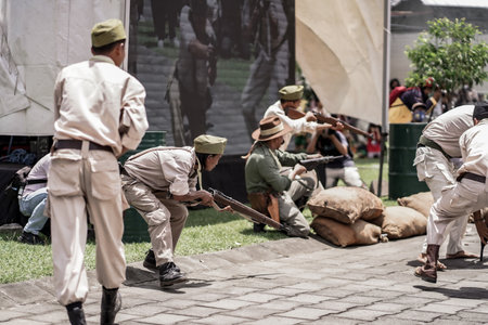 theatrical war general attack 1 march, using war uniforms and weapons in the Dutch colonial era. They shoot each other. : Yogyakarta, Indonesia - 01 March 2022のeditorial素材