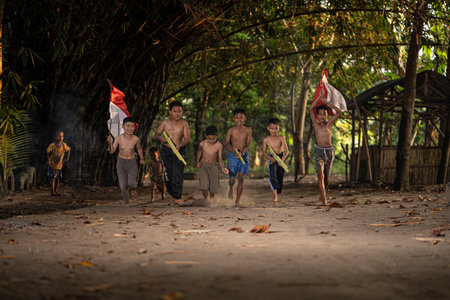 Concept photo of village children who are excited and play in the Indonesian independence edition carrying the flag. : Bantul, Indonesia - 15 August 2021のeditorial素材