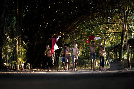 Concept photo of village children who are excited and play in the Indonesian independence edition carrying the flag. : Bantul, Indonesia - 15 August 2021のeditorial素材