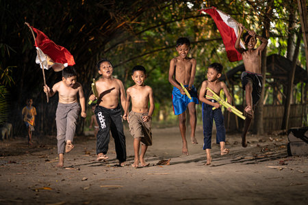 Concept photo of village children who are excited and play in the Indonesian independence edition carrying the flag. : Bantul, Indonesia - 15 August 2021のeditorial素材