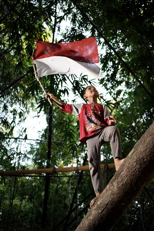Concept photo of village children who are excited and play in the Indonesian independence edition carrying the flag. : Bantul, Indonesia - 15 August 2021のeditorial素材