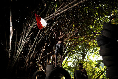 Concept photo of village children who are excited and play in the Indonesian independence edition carrying the flag. : Bantul, Indonesia - 15 August 2021のeditorial素材