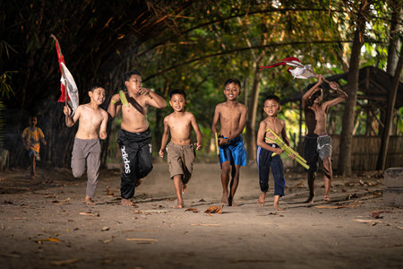 Concept photo of village children who are excited and play in the Indonesian independence edition carrying the flag. : Bantul, Indonesia - 15 August 2021のeditorial素材
