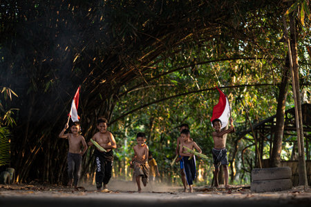 Concept photo of village children who are excited and play in the Indonesian independence edition carrying the flag. : Bantul, Indonesia - 15 August 2021のeditorial素材