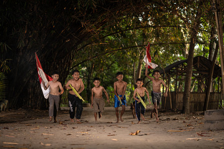 Concept photo of village children who are excited and play in the Indonesian independence edition carrying the flag. : Bantul, Indonesia - 15 August 2021のeditorial素材